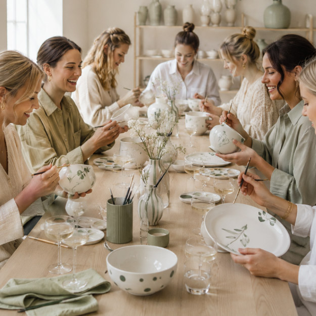 Junge Frauen an einem Tisch zum malen von Porzellan